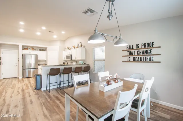 a view of a dining room and livingroom with furniture wooden floor a chandelier