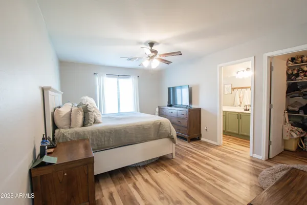 a spacious bedroom with a bed and a chandelier
