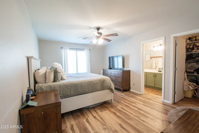 a spacious bedroom with a bed and a chandelier