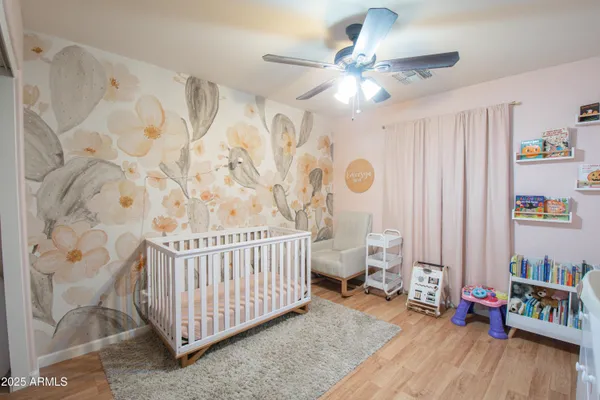a bedroom with baby bed and a window