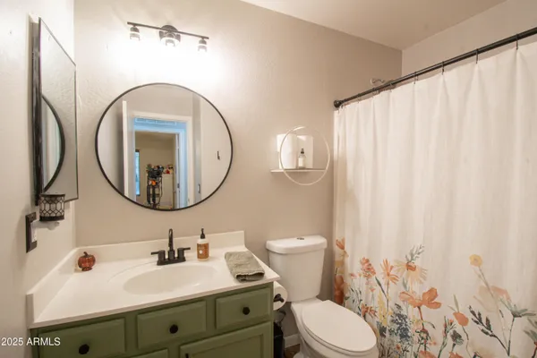 a bathroom with a sink a mirror a toilet and a mirror