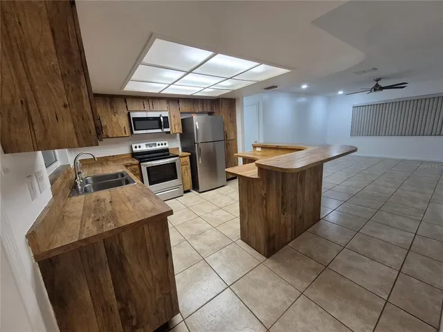 an empty room with staircase and fan