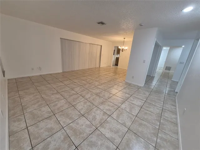an empty room with windows and ceiling fan