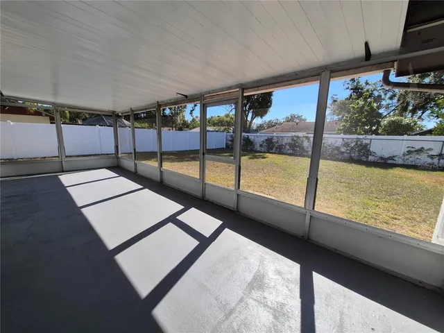 a view of an empty room with a floor to ceiling window and an outdoor view