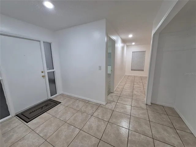 a view of hallway with a window and a refrigerator