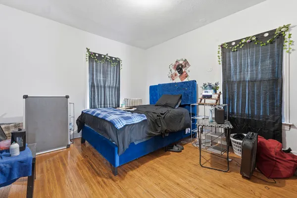 a bedroom with a bed and wooden floor