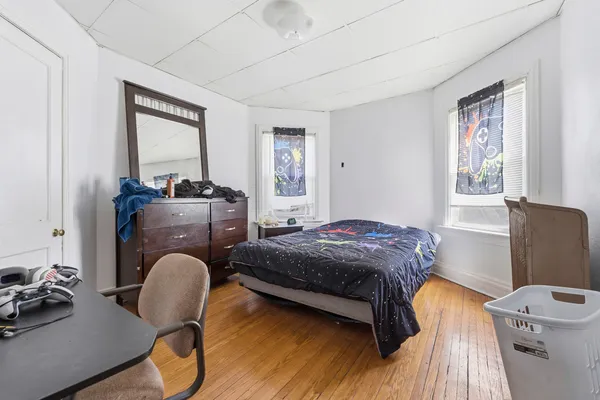 a bedroom with a bed chair and a window