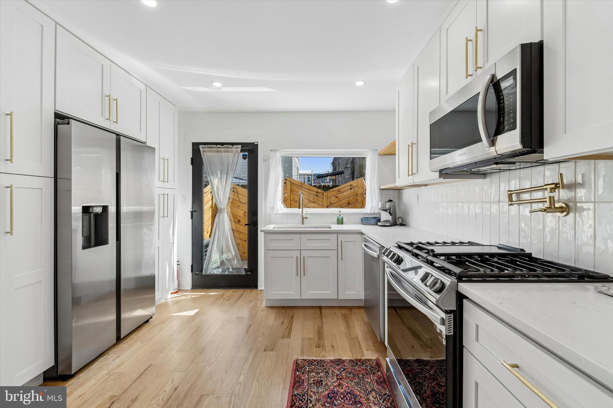 2565 Tulip Street Philadelphia, PA 19125 - Photo 7 of 15 a kitchen with stainless steel appliances granite countertop a stove a refrigerator and a microwave