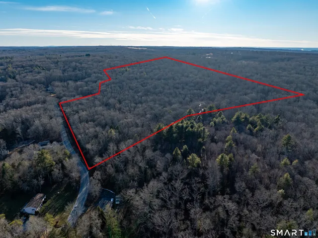 an aerial view of house with yard and mountain view in back