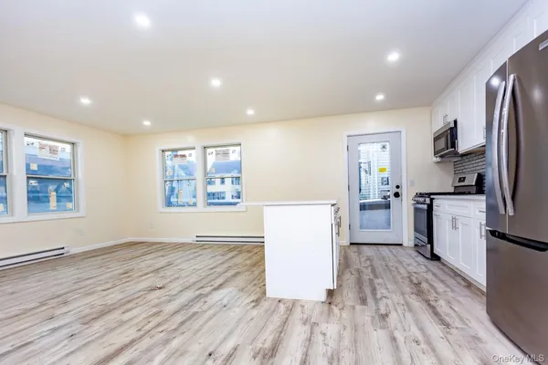 a kitchen with a refrigerator and a stove top oven