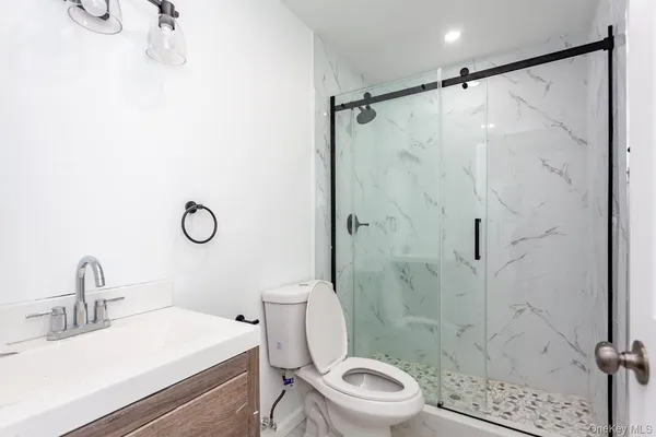 a bathroom with a sink a toilet and shower