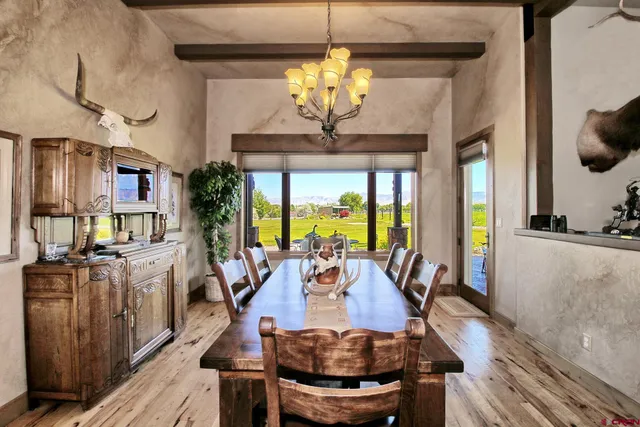 a view of a dining room with furniture a chandelier and wooden floor
