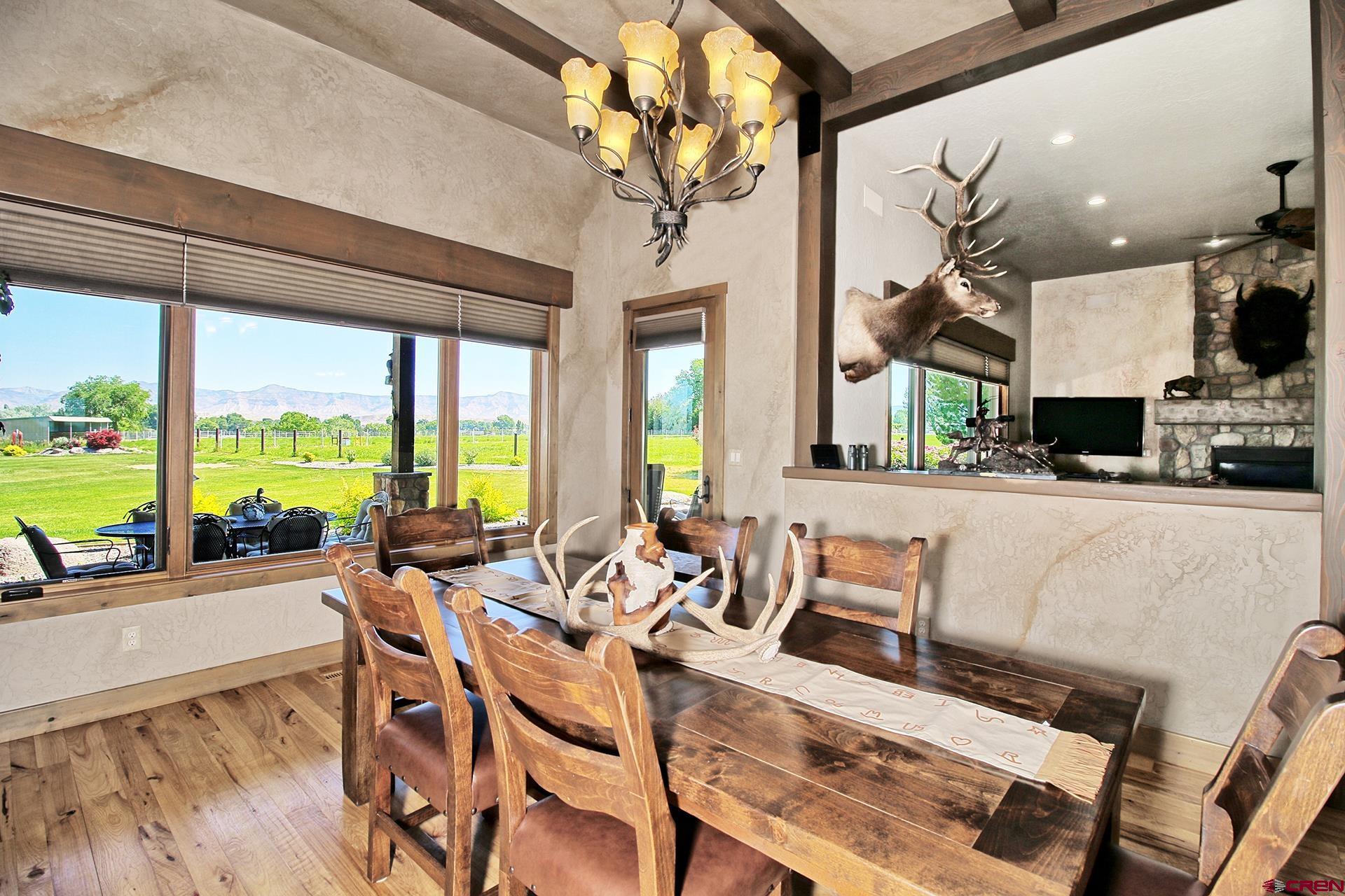971 24 Road Grand Junction, CO 81505 - Photo 16 of 43 a view of a dining room with furniture a chandelier and large windows
