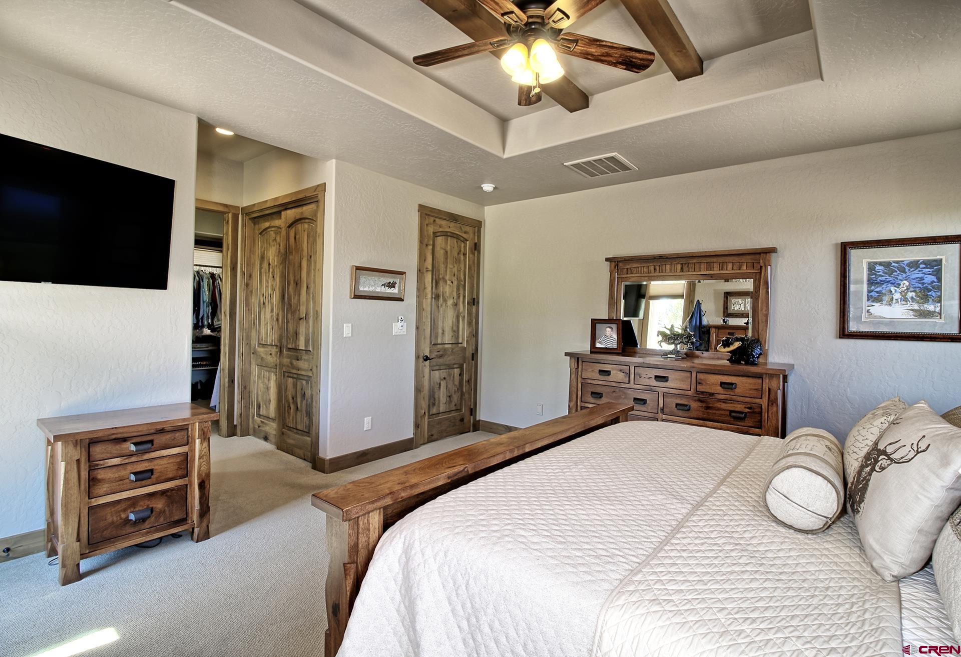 971 24 Road Grand Junction, CO 81505 - Photo 19 of 43 a bedroom with a bed and a flat tv screen on dresser
