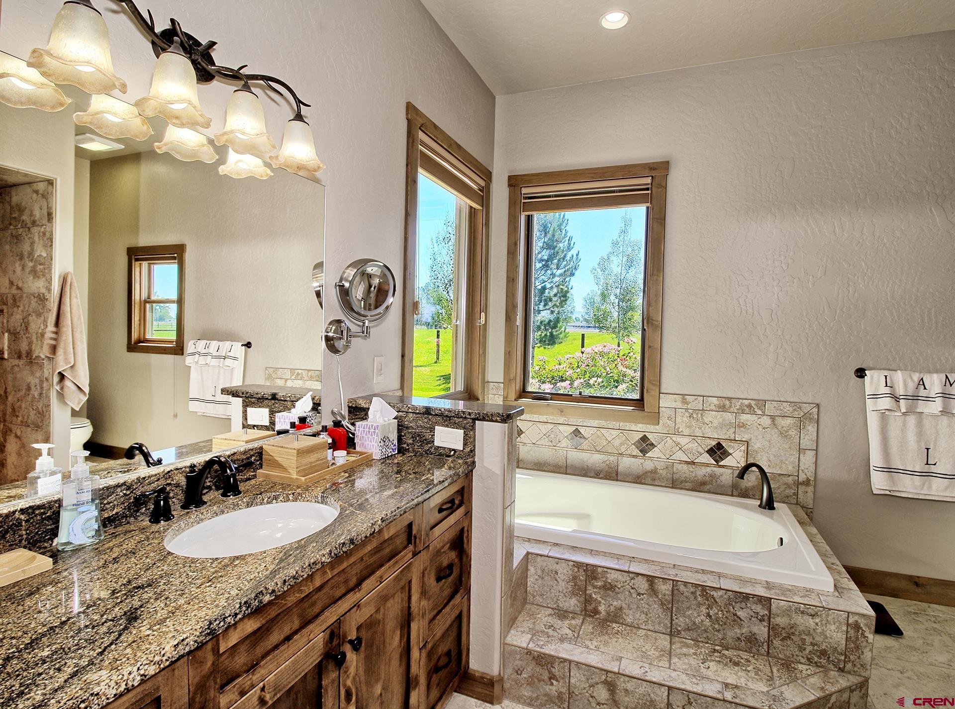 971 24 Road Grand Junction, CO 81505 - Photo 20 of 43 a bathroom with a granite countertop tub and a sink