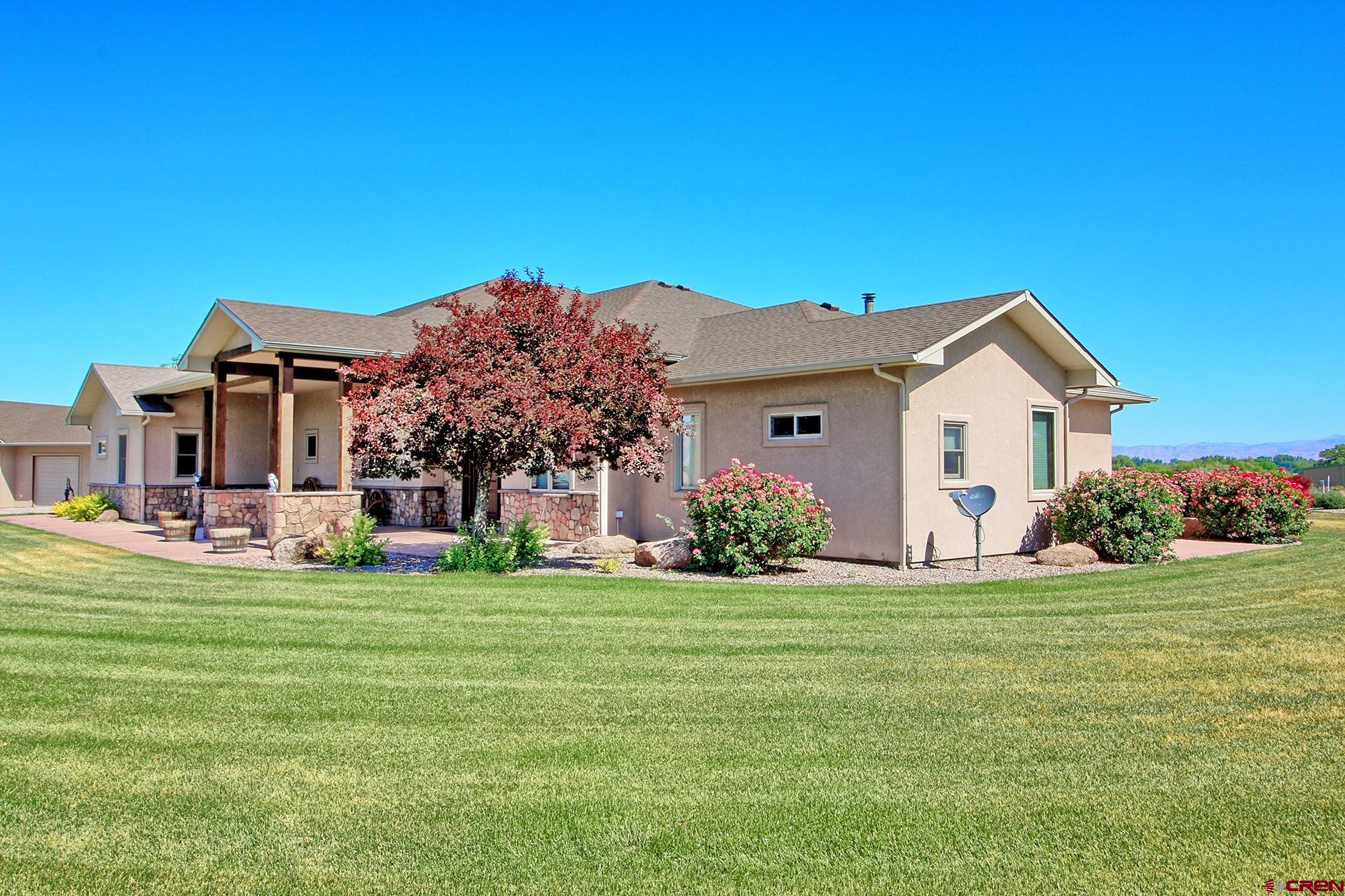 971 24 Road Grand Junction, CO 81505 - Photo 2 of 43 a front view of a house with a garden