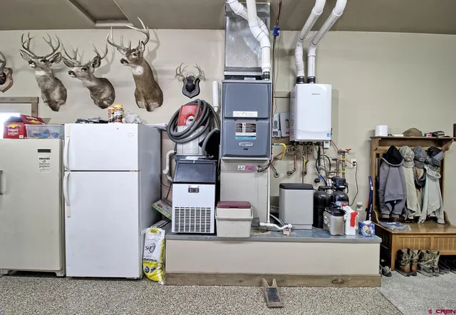 a utility room with lots of clutter and refrigerator