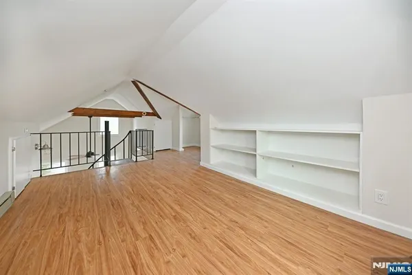 a view of a room with wooden floors and white walls