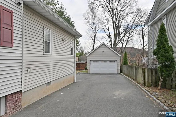 a view of a house with a small yard and a large tree