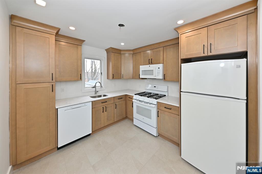 205 Union Street, Unit 2 Ridgewood, NJ 07450 - Photo 8 of 24 a kitchen with a refrigerator a sink and white cabinets
