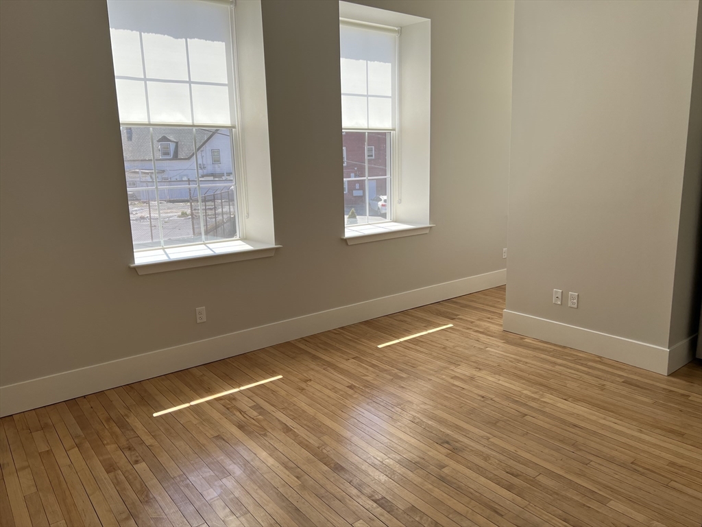 34 St Joseph Street, Unit 21 Fall River, MA 02723 - Photo 2 of 15 an empty room with wooden floor and windows