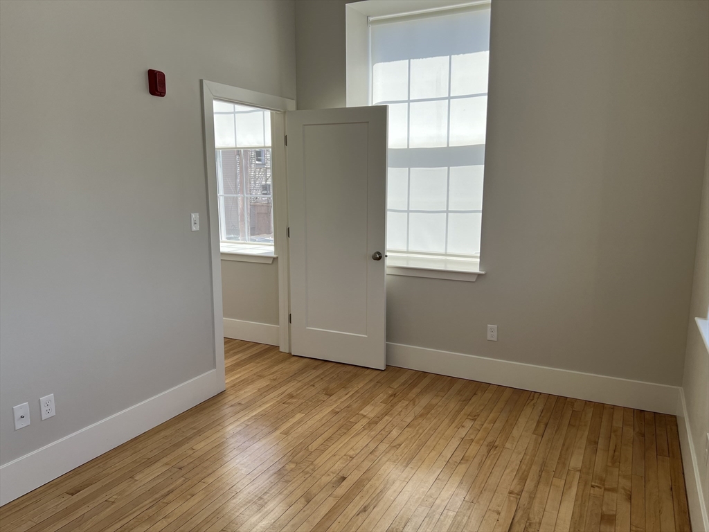 34 St Joseph Street, Unit 21 Fall River, MA 02723 - Photo 4 of 15 an empty room with wooden floor and windows