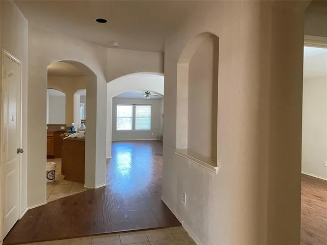 a view of a hallway with wooden floor and a living room