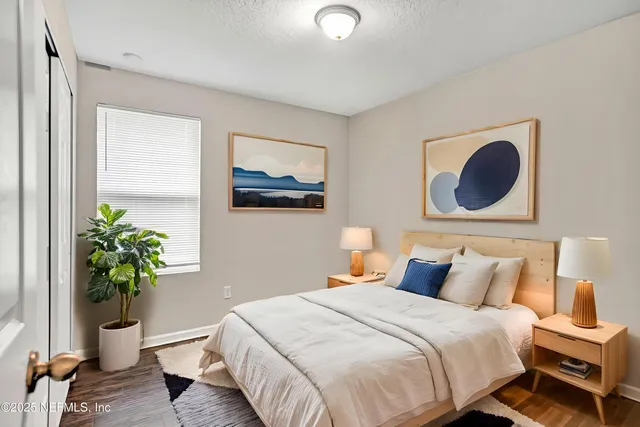 a bedroom with a bed lamp and a potted plant