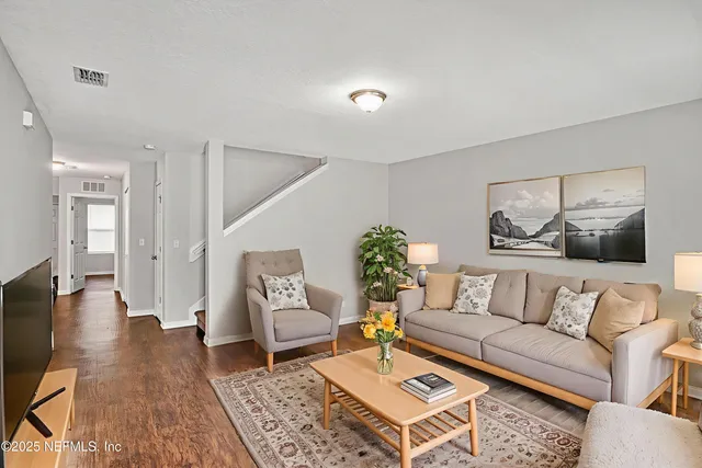 a living room with furniture and wooden floor