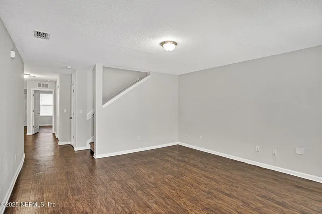 a view of a big room with wooden floor and windows