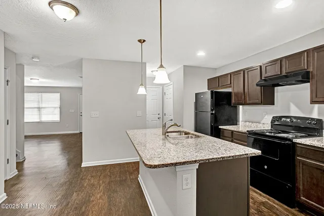a kitchen with stainless steel appliances granite countertop a sink stove and refrigerator