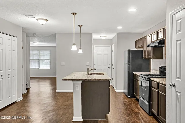 a kitchen with stainless steel appliances granite countertop a sink stove and refrigerator
