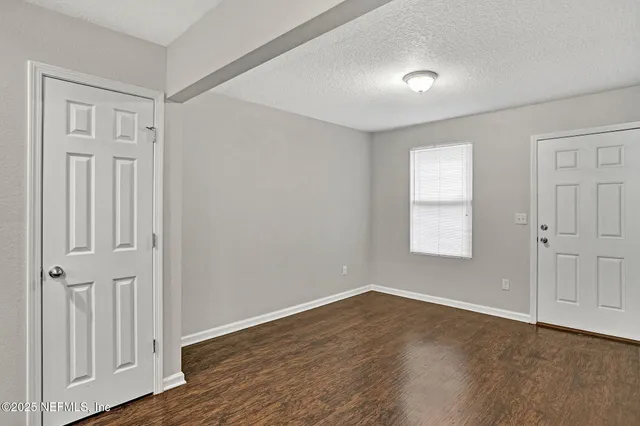 an empty room with wooden floor and closet area