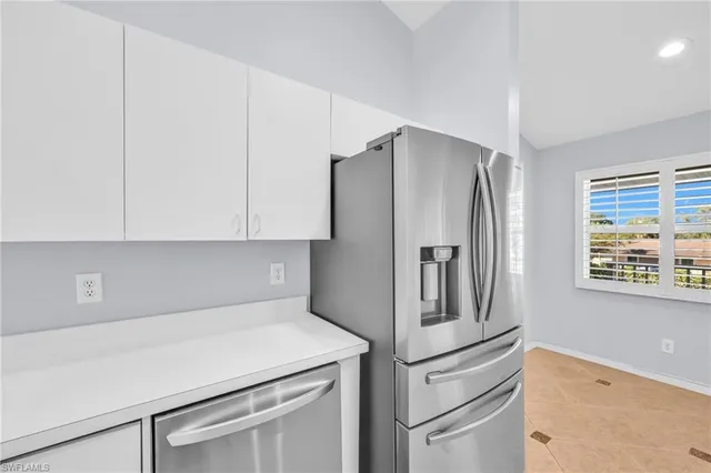 a kitchen with stainless steel appliances white cabinets and a refrigerator