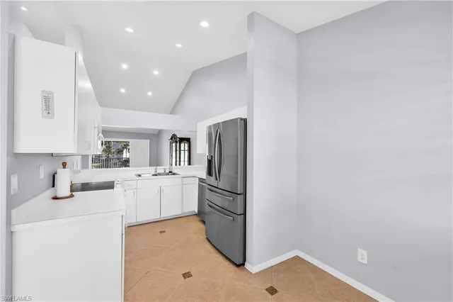 a kitchen with a refrigerator and white cabinets