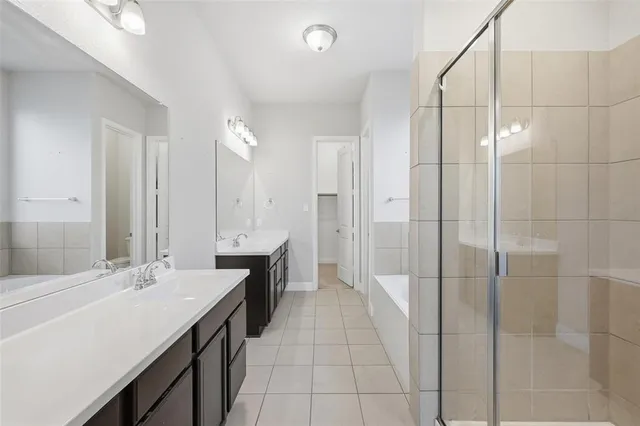 a bathroom with a double vanity sink mirror and shower