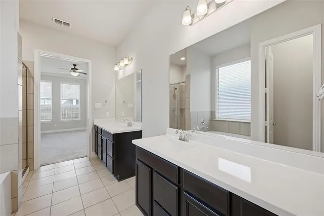 a large bathroom with a double vanity sink mirror and shower