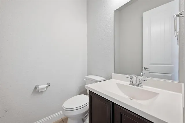 a bathroom with a granite countertop sink a toilet and a mirror