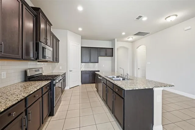 a kitchen with stainless steel appliances granite countertop a sink stove and cabinets