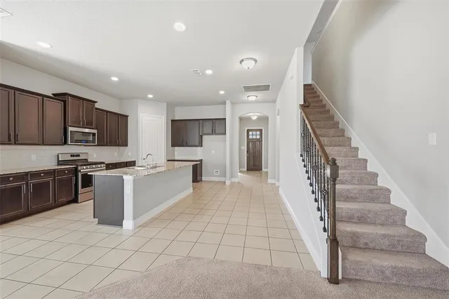 a large white kitchen with a stove a sink and a refrigerator