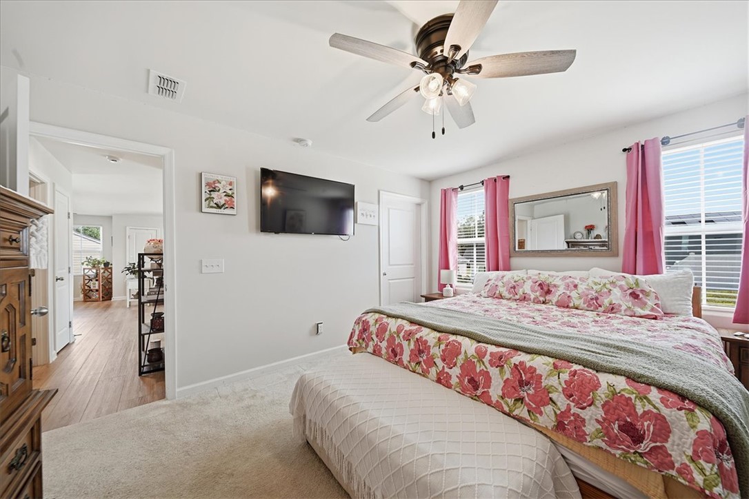 117 Alice Court Easley, SC 29642 - Photo 10 of 26 Well-lit sleeping quarters with a ceiling fan for comfort and hardwood flooring leading to additional areas.