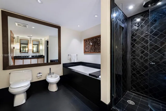 a bathroom with a granite countertop sink toilet a mirror and shower