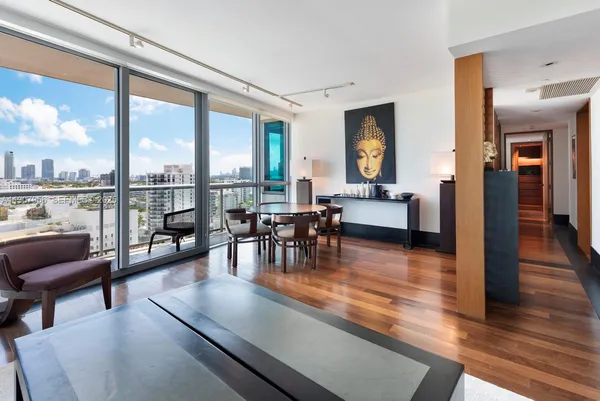 a living room with furniture and floor to ceiling windows