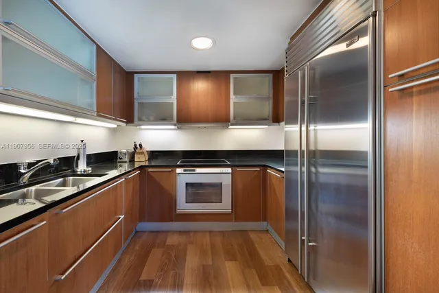 a kitchen with kitchen island a counter top space a sink and stainless steel appliances