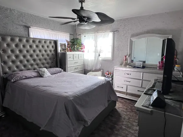 a bedroom with a bed and a mirror on the dresser