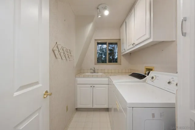 a utility room with sink dryer and washer