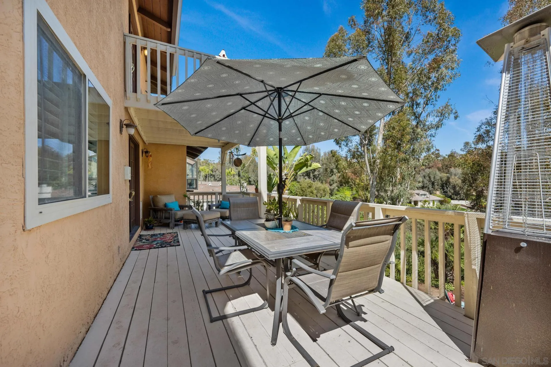 10575 Spruce Grove Avenue San Diego, CA 92131 - Photo 28 of 33 a view of a patio with a table and chairs under an umbrella with wooden floor