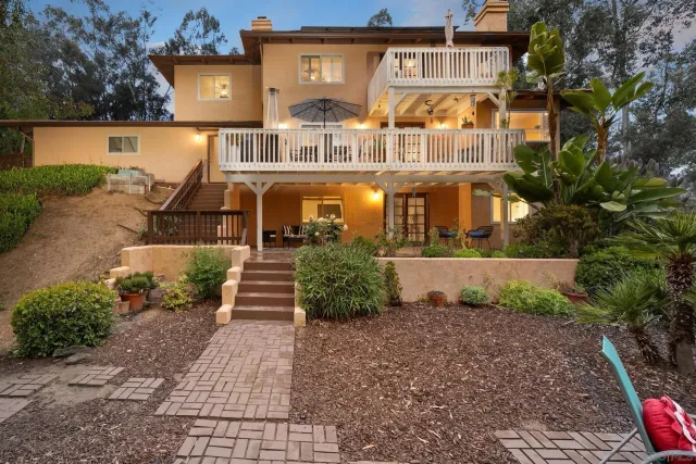 a front view of a house with a yard and potted plants