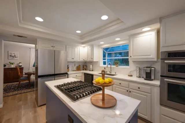 a kitchen with a stove a sink cabinets and a wooden floor