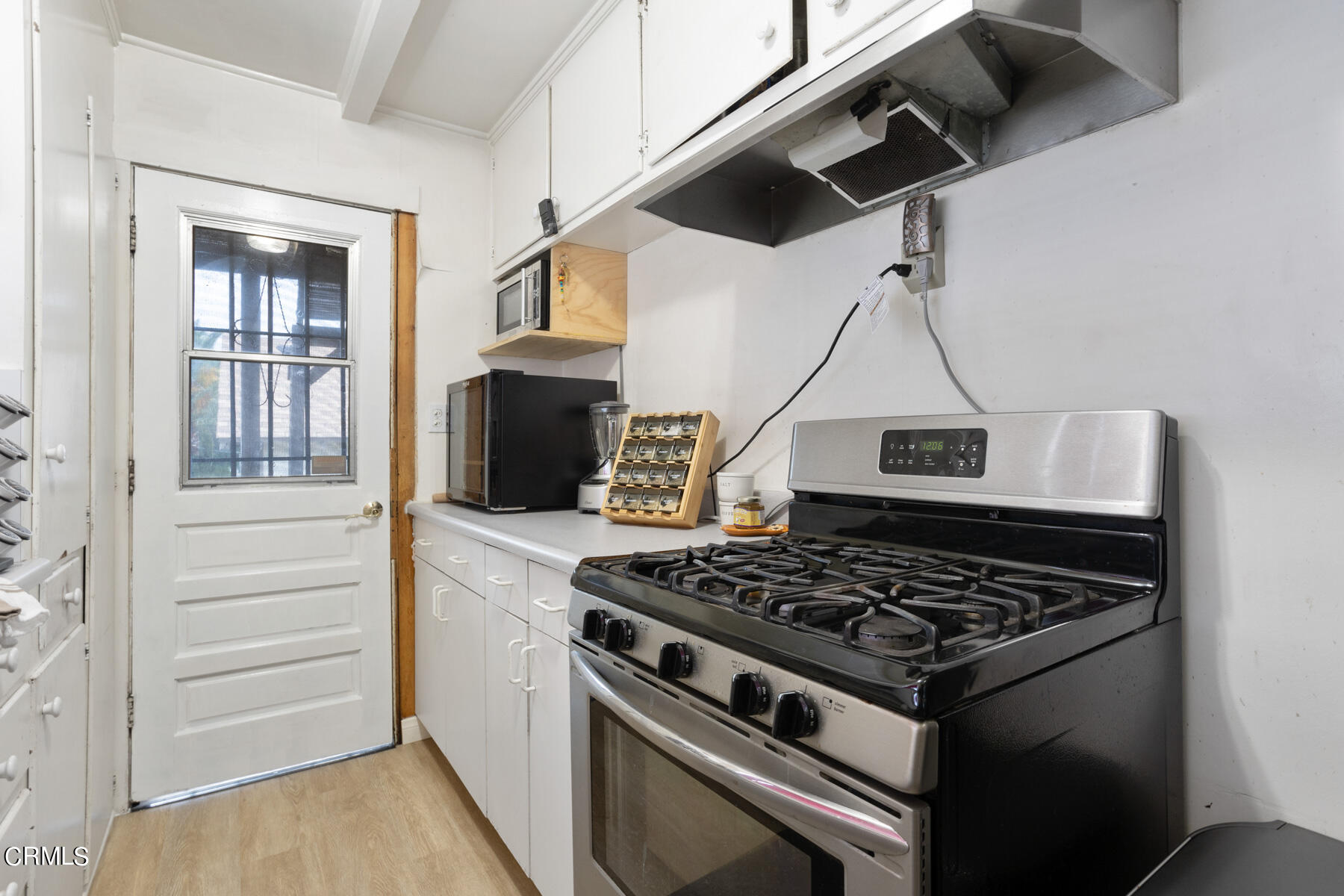 7518 Kyle Street Tujunga, CA 91042 - Photo 14 of 28 a kitchen stove sitting inside of a kitchen with white cabinets